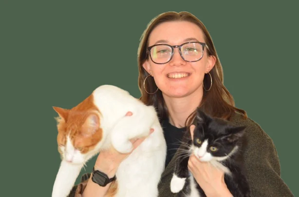 Meggie Brody smiling, holding an orange-and-white cat and a black-and-white kitten